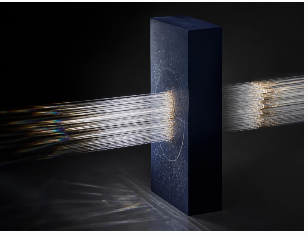 Light filaments travelling through a dark navy sculptural structure